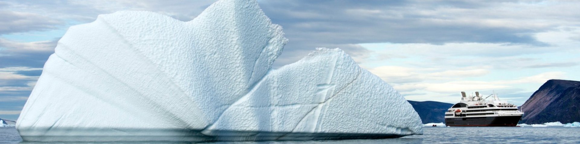 Kreuzfahrtschiff neben einem Eisberg