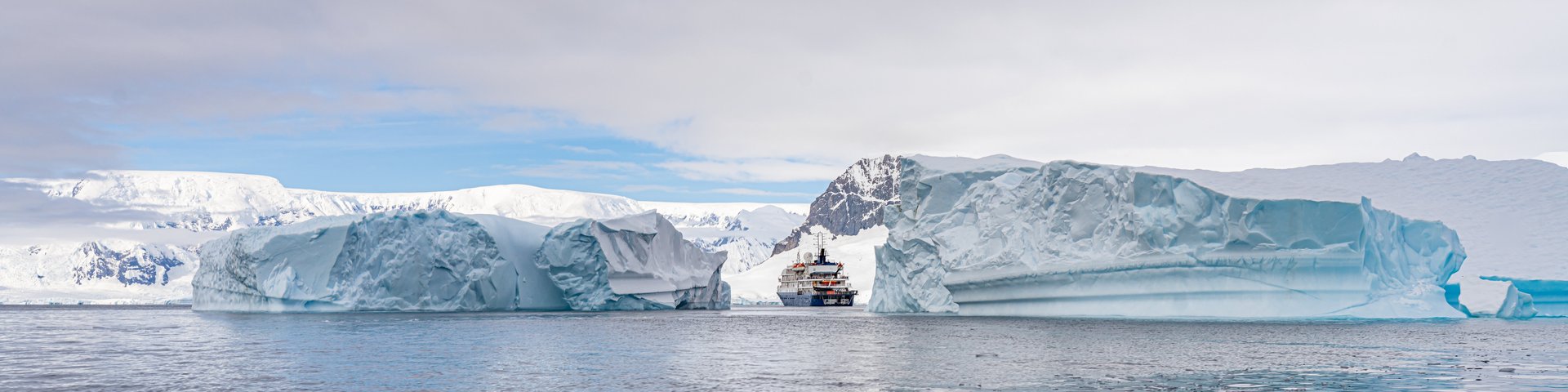 Schiff in einer Bucht in der Antarktis mit Eislandschaft