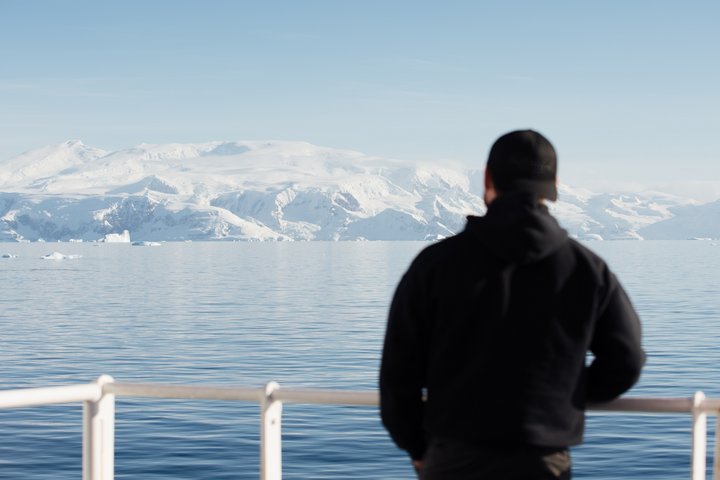 Mensch schaut über eine Bucht in Antarktika