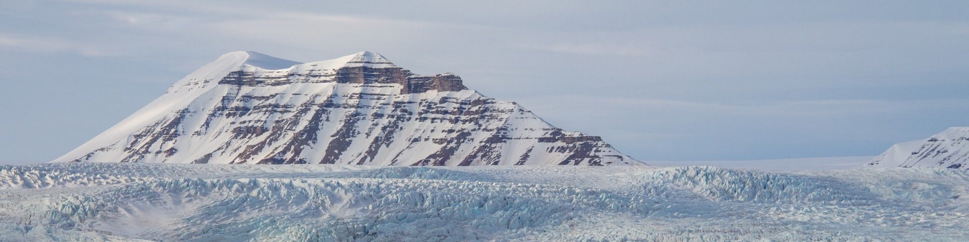 Bucht mit verschneitem Berg im Hintergrund