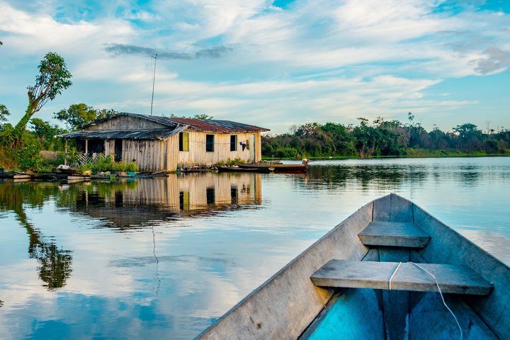 Der Amazonas mit Haus am Ufer vom Kanu aus