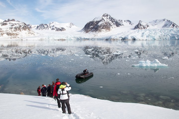 Zodiac in der Bucht und Gäste an Land auf Spitzbergen
