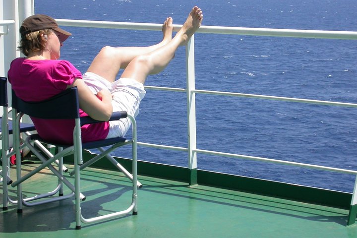 Frau an Bord eines Frachtschiffes auf einem Stuhl