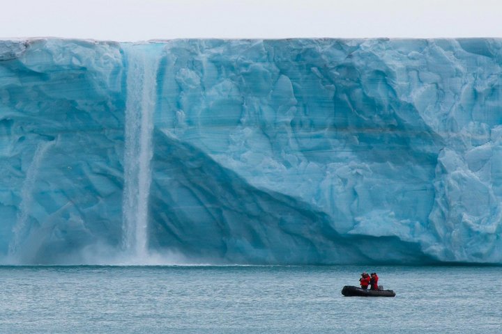 Zodiac vor einem Wasserfall und Eisberg