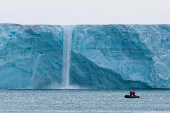 Zodiac vor einem Wasserfall und Eisberg