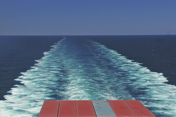Container am Heck eines Containerschiffes und Fahrwasser