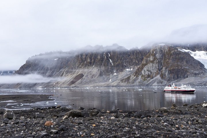 Hurtigruten-Schiff in Bucht in Spitzbergen mit Wolken