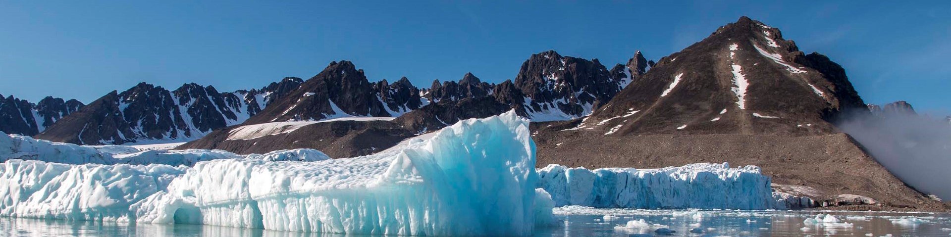 Eisscholle in einer Bucht mit Berg im Hintergrund