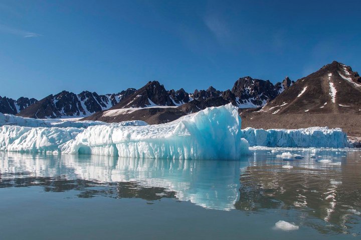 Eisscholle in einer Bucht mit Berg im Hintergrund