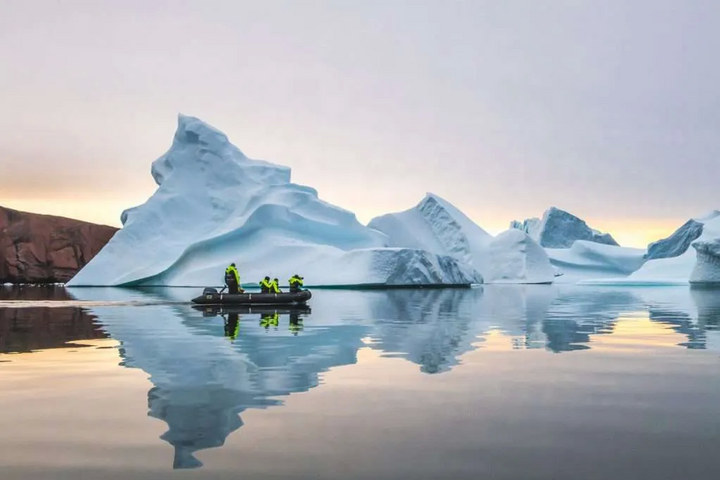 Eisberg in Bucht mit Zodiac im Vordergrund